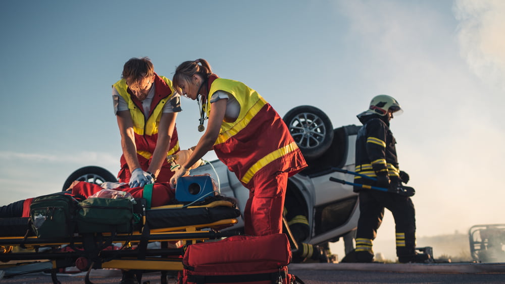 paramedics treating an injured person after a car accident