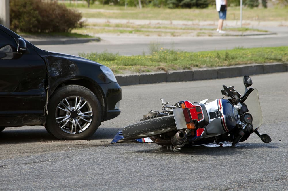 Motorcycle lying on the road after colliding with a car