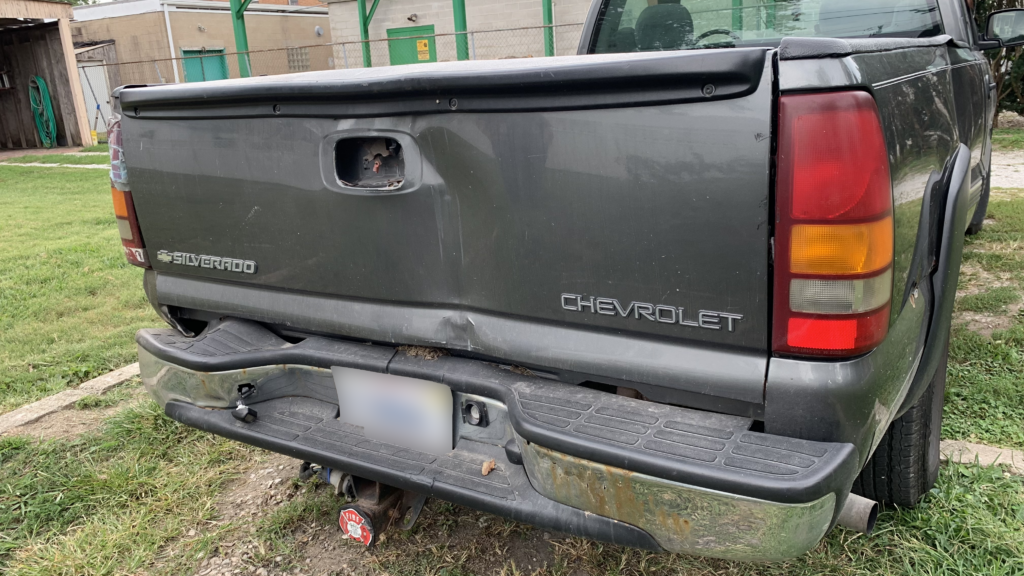 minor damage on the rear end of silver truck after auto accident